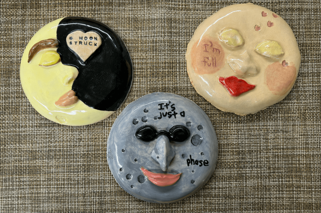 Three round ceramic moon faces showing different lunar phases.